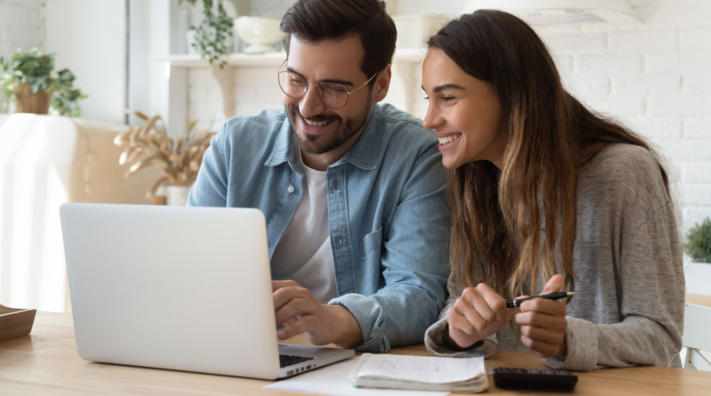 Un couple consulte ensemble l'application mobile de leur compte bancaire partagé sur smartphone dans un intérieur contemporain, lumière naturelle douce